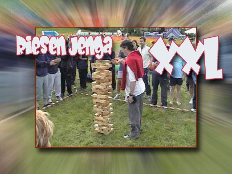 Eine Person zieht einen Stein aus dem XXL Jenga Spiel