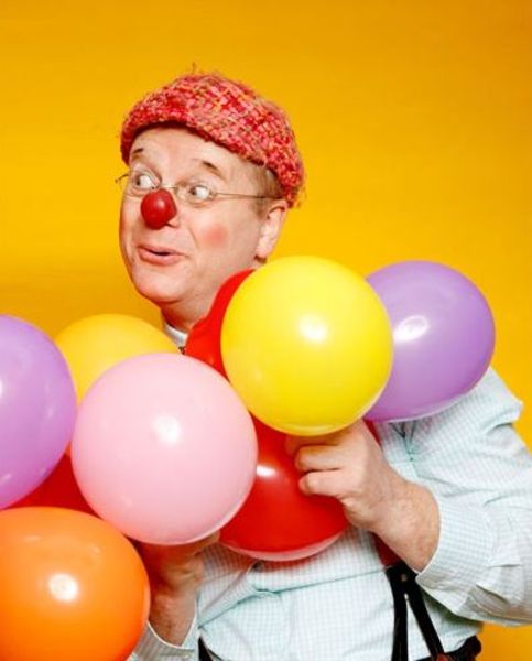 Ein Clown mit roter Nase und Luftballons