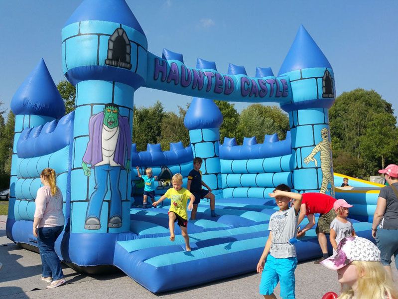 Große blaue Hüpfburg mit Kindern darauf