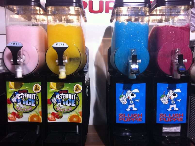 Vier Slusheis Maschinen mit bunten Füllungen