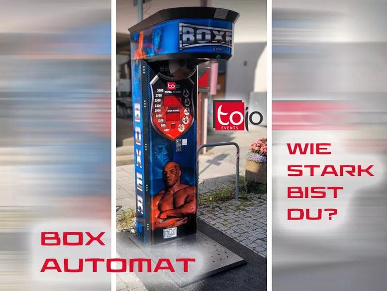 Blau schwarzer Boxautomat mit Mike Tyson Motiv und der Aufschrift Wie stark bist du von Tojo Events im Außenbereich