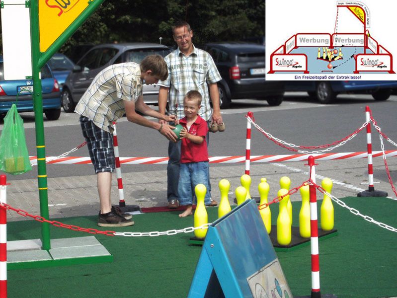 Ein Junge wird beim Kegeln von einem älteren Kind unterstützt